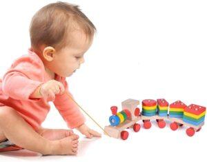 a toddler pulling the wooden stacking train