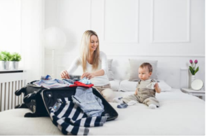 A mom packing the luggage with a toddler boy