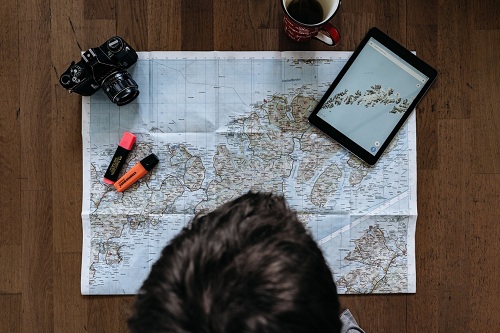 person looking at map on brown parquet floor