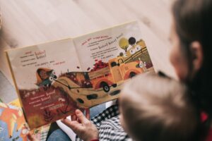 The importance of reading with toddlers-Woman Reading Book to Toddler