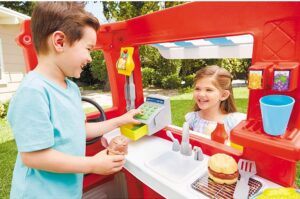 a boy and a gril playing with pretend play food truck