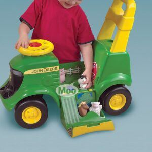 a boy playing with the John Deere Activity Tractor