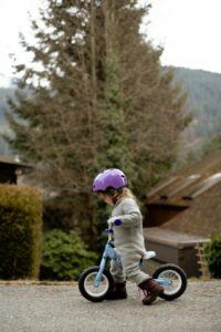 a toddler girl riding a balance bike