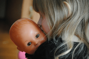 toddler carry a baby doll